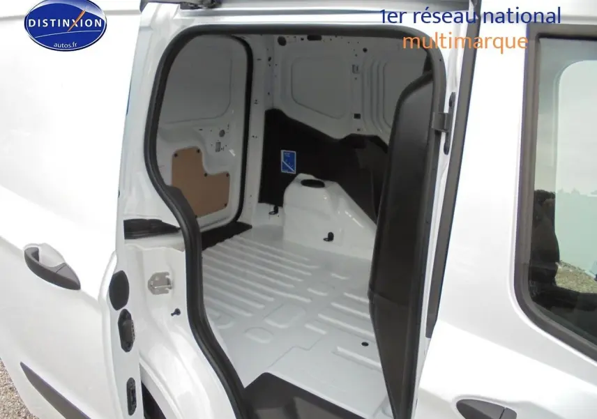Vue intérieure du fourgon Ford Transit Courier blanc glacier, montrant l'espace de chargement vide avec porte latérale ouverte.