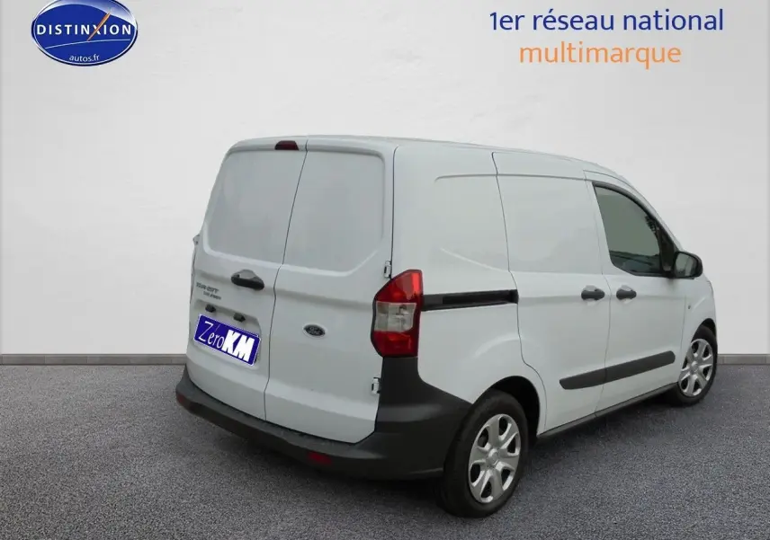 Vue 3/4 arrière droite d'un Ford Transit Fourgon Courier blanc glacier avec portes arrière battantes et protections noires.