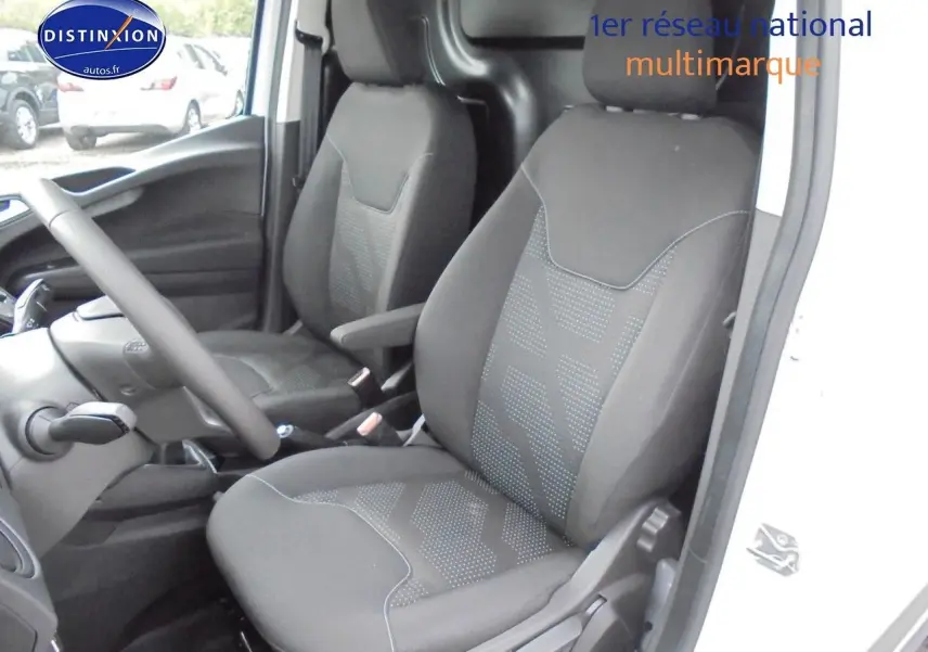 Intérieur du Ford Transit Courier 2022 montrant les sièges avant noirs et la console côté conducteur, porte ouverte côté droit.