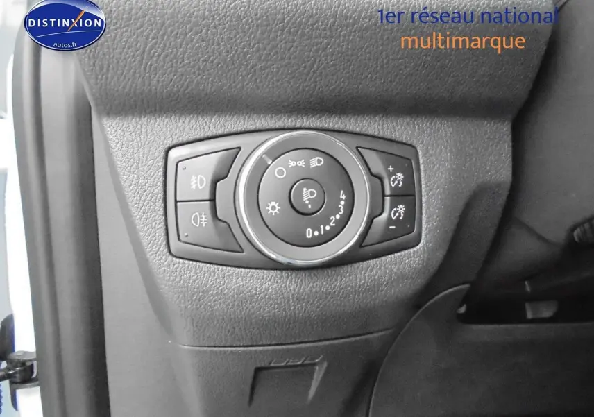 Gros plan sur le panneau de commande des phares du Ford Transit Fourgon Courier blanc glacier, côté gauche intérieur conducteur.