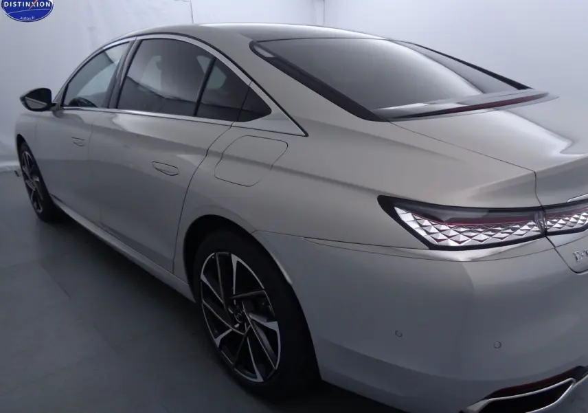 Vue 3/4 arrière droit d'une DS9 hybride rechargeable couleur Crystal Pearl nacré avec feux arrière à motif géométrique.