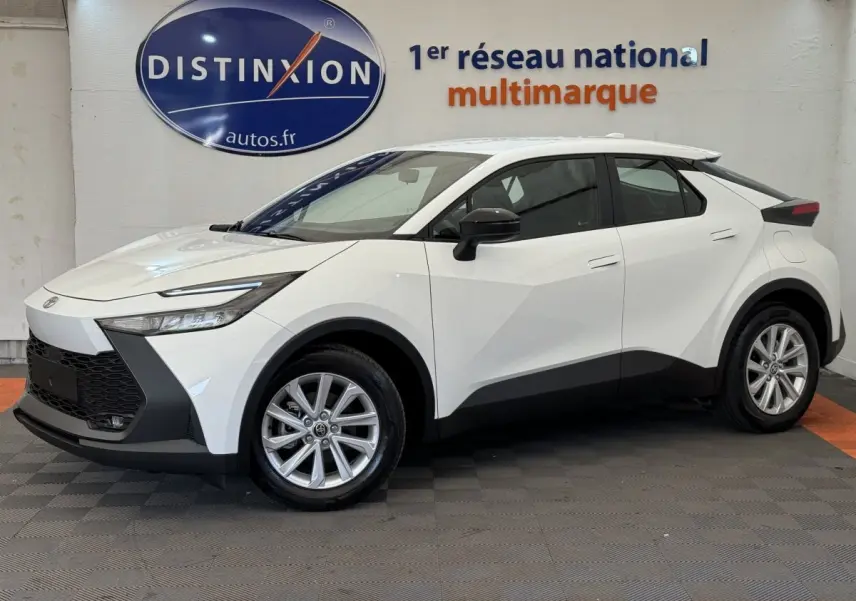 Profil côté gauche du Toyota C-HR blanc 2024 avec calandre noire et jantes alliage en showroom.