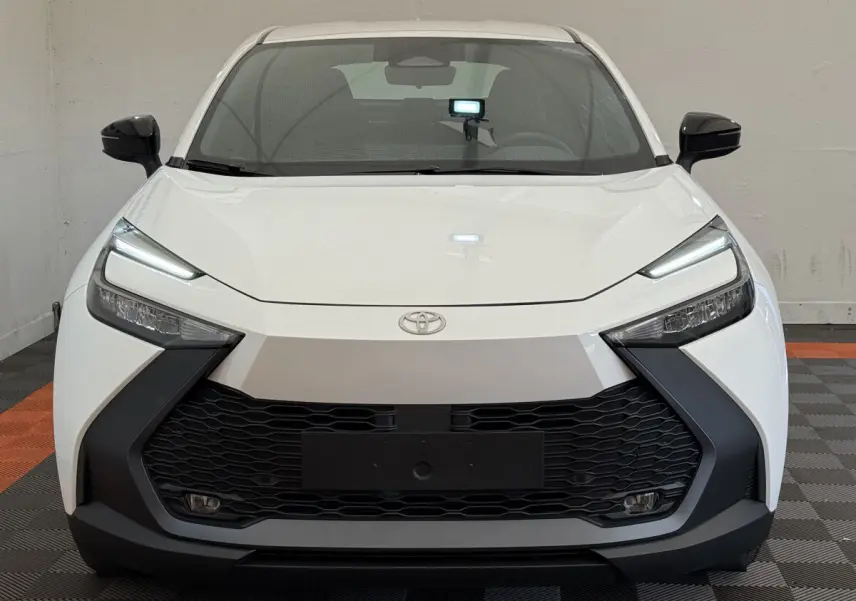 Vue frontale du Toyota C-HR 1.8 Hybride 140 Dynamic blanc avec calandre noire et phares LED fins.