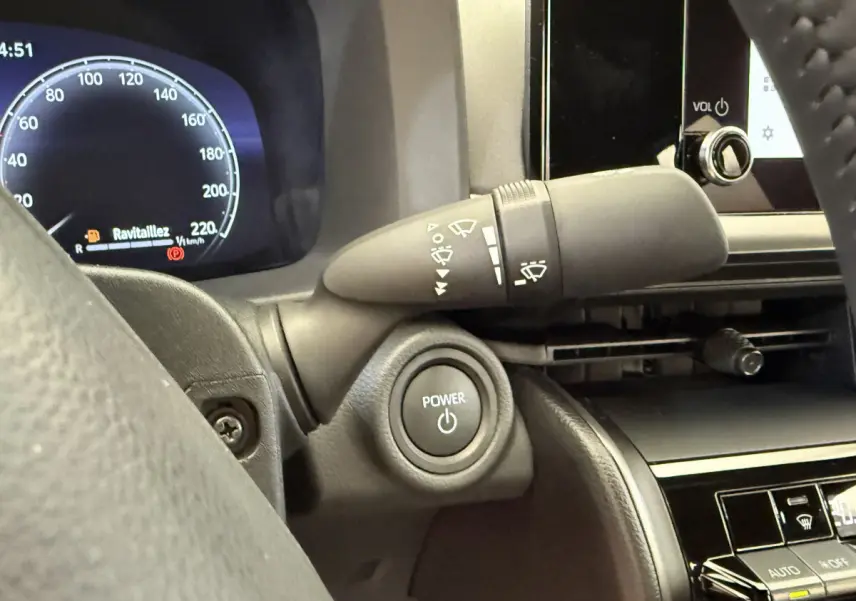 Gros plan sur le bouton Power et le commodo d'essuie-glace côté gauche du tableau de bord du Toyota C-HR blanc 2024.