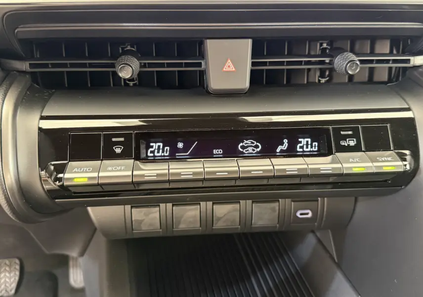 Panneau de commande de climatisation digitale du Toyota C-HR blanc 2024, affichage température à 20°C, boutons lumineux.