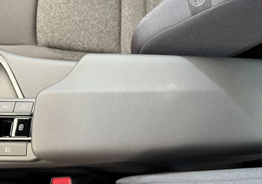 Accoudoir central gris foncé avec commandes électroniques, siège tissu gris, intérieur Toyota C-HR 1.8 Hybride 2024.