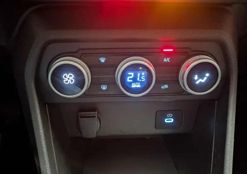 Gros plan sur les commandes de climatisation numérique du tableau de bord du Dacia Jogger gris schiste métal.