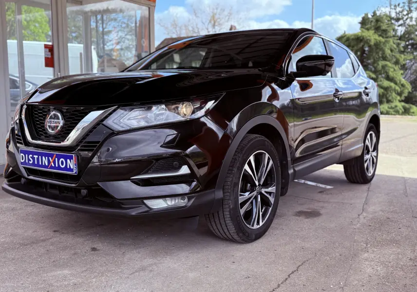 Nissan Qashqai noir vu en 3/4 avant droit, mettant en valeur ses jantes alliage et sa calandre chromée.