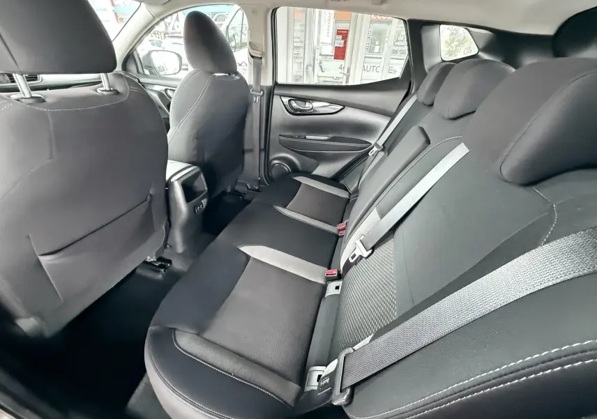 Intérieur arrière du Nissan Qashqai noir 2020, vue côté droit montrant les sièges en tissu noir avec ceintures grises.