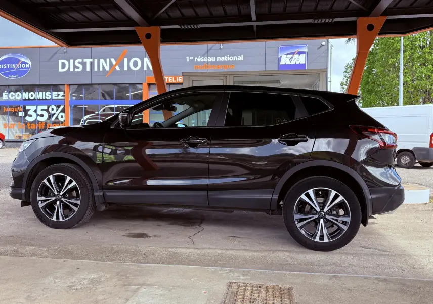 Vue latérale droite d’un Nissan Qashqai noir 2020, avec jantes alliage et carrosserie brillante sous un abri.