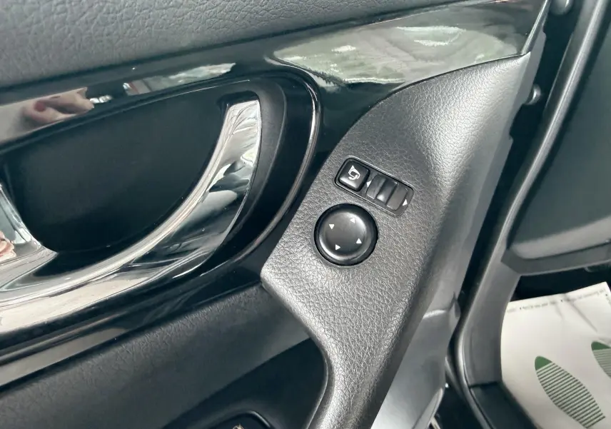 Gros plan sur la commande de réglage des rétroviseurs côté conducteur du Nissan Qashqai noir, intérieur noir.