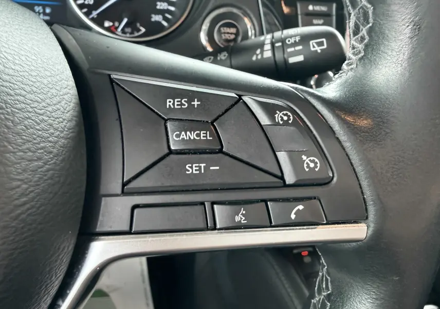 Gros plan sur les commandes de régulateur de vitesse au volant noir du Nissan Qashqai 2020.