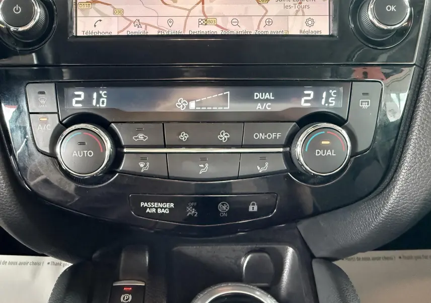 Vue rapprochée de la console centrale du Nissan Qashqai 2020, avec commandes de climatisation digitale et écran tactile.
