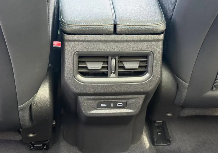 Vue rapprochée de la console arrière noire avec bouches d’aération et ports USB du Renault Austral gris Schiste satin.