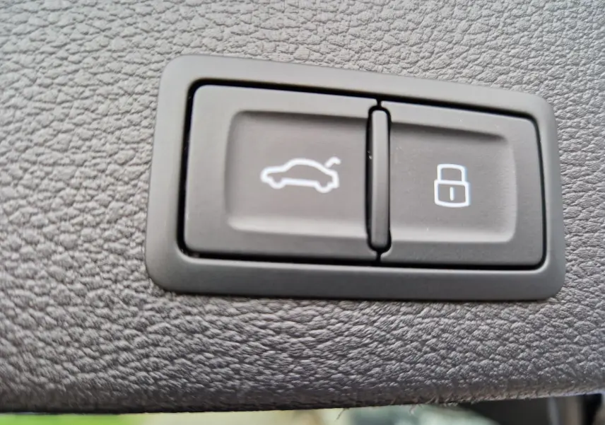 Gros plan sur les boutons d'ouverture du coffre et de verrouillage dans l'habitacle d'un Audi Q2 noir Mito Metal 2023