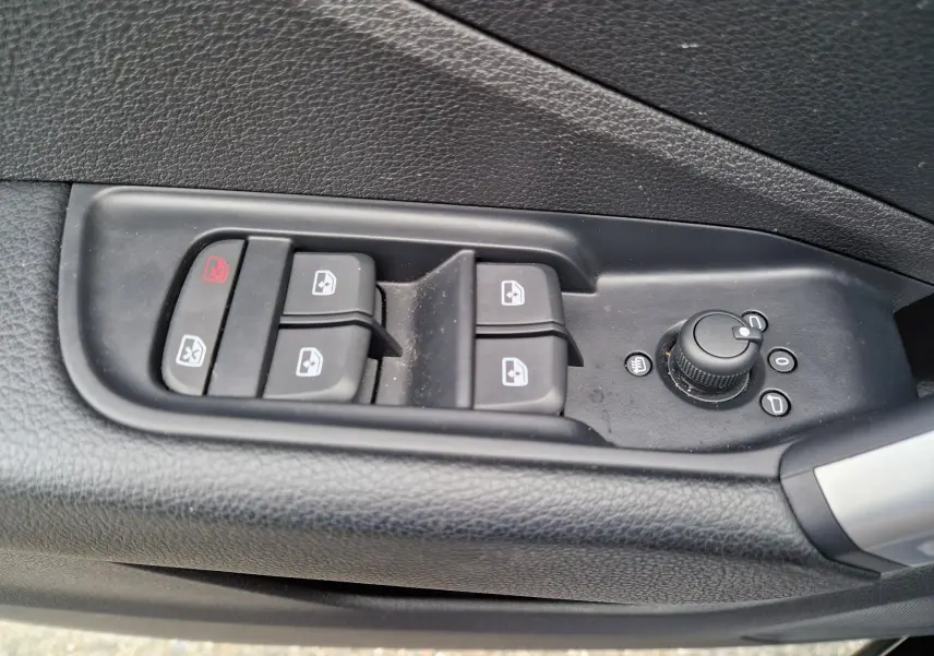 Commande des vitres électriques et réglage des rétroviseurs côté gauche d'une Audi Q2 noire Mito Metal 2023.