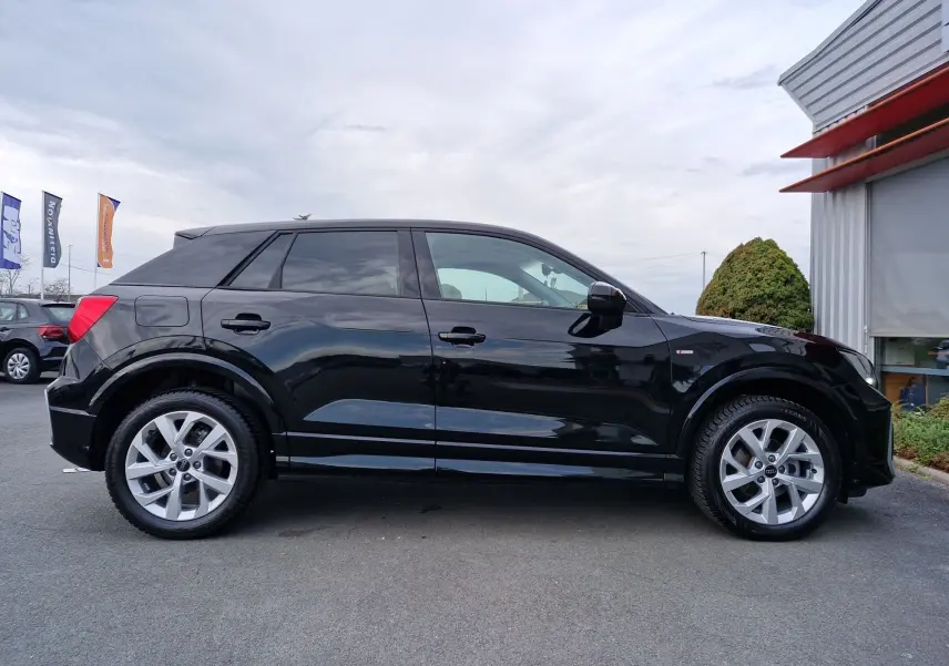Audi Q2 35 TFSI noir mito metal vue de profil côté gauche, jantes alliage 17 pouces et lignes dynamiques.