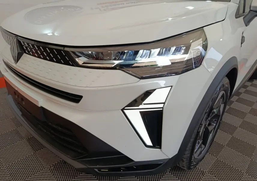 Gros plan sur l'avant droit du Renault Captur blanc 2025 avec phares LED et calandre moderne.