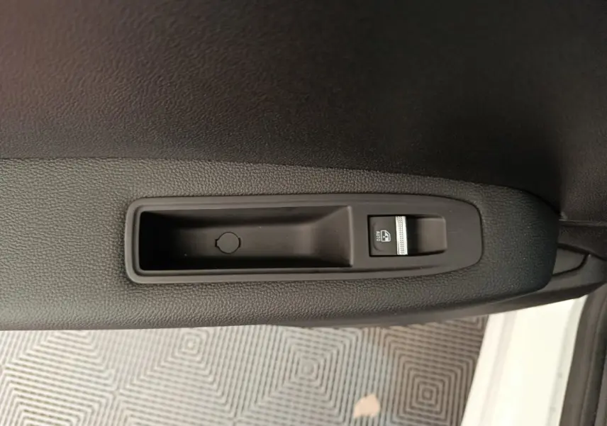 Gros plan sur la commande de lève-vitre côté gauche dans l'habitacle du Renault Captur blanc 2025.
