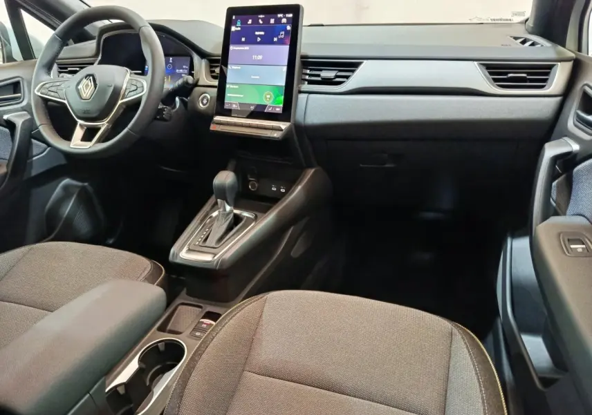 Intérieur du Renault Captur Techno E-Tech 2025, vue du tableau de bord et console centrale avec écran tactile vertical.