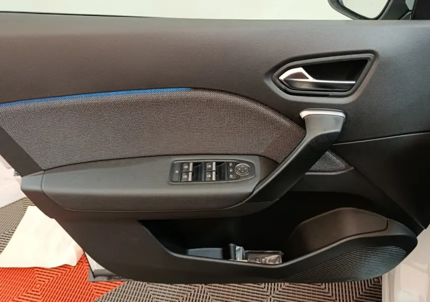 Panneau de porte avant gauche noir avec commandes électriques sur Renault Captur blanc hybride 2025.