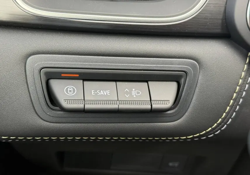 Gros plan sur les boutons de commande E-SAVE et réglage des phares dans l'habitacle noir du Renault Symbioz gris Rafale.