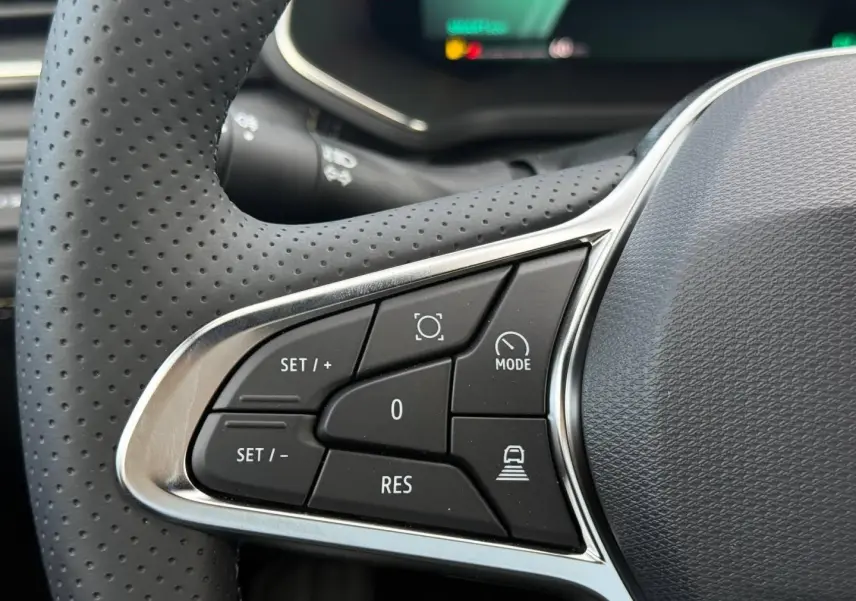 Gros plan sur les commandes multifonctions côté gauche du volant perforé du Renault Symbioz gris Rafale.