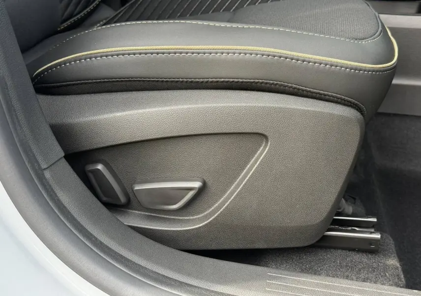 Détail du siège avant droit gris avec commandes électriques et surpiqûres contrastantes dans une Renault SYMBIOZ 2026.