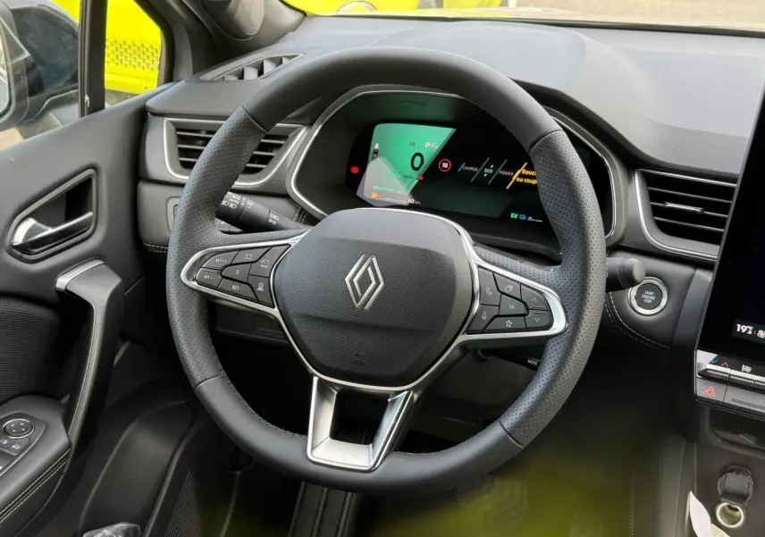 Vue intérieure centrée sur le volant noir perforé du Renault SYMBIOZ 2026 avec tableau de bord numérique.