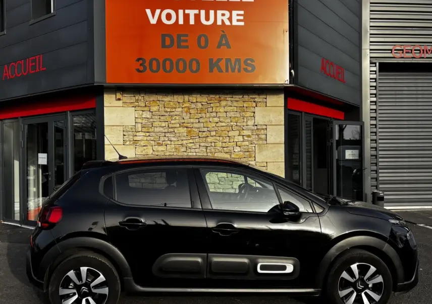 Vue de profil côté gauche d'une Citroën C3 noire 2024 avec protections latérales distinctives et jantes bicolores.