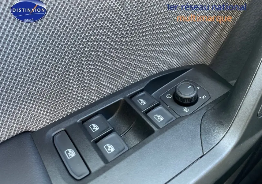 Gros plan sur les commandes des vitres électriques et rétroviseurs côté conducteur d'une SEAT Leon gris magnétique 2024.