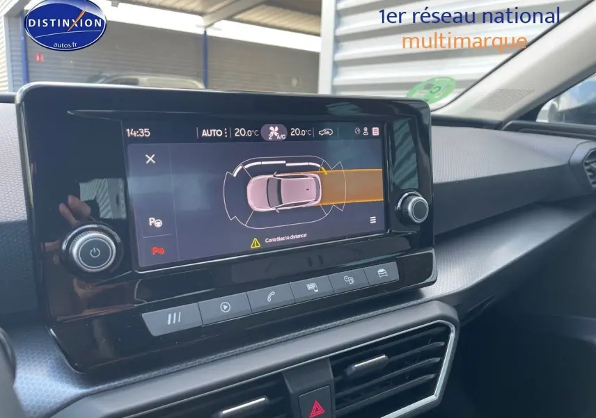 Vue rapprochée de l'écran tactile central du tableau de bord de la SEAT LEON gris magnétique, affichant l'aide au stationnement.