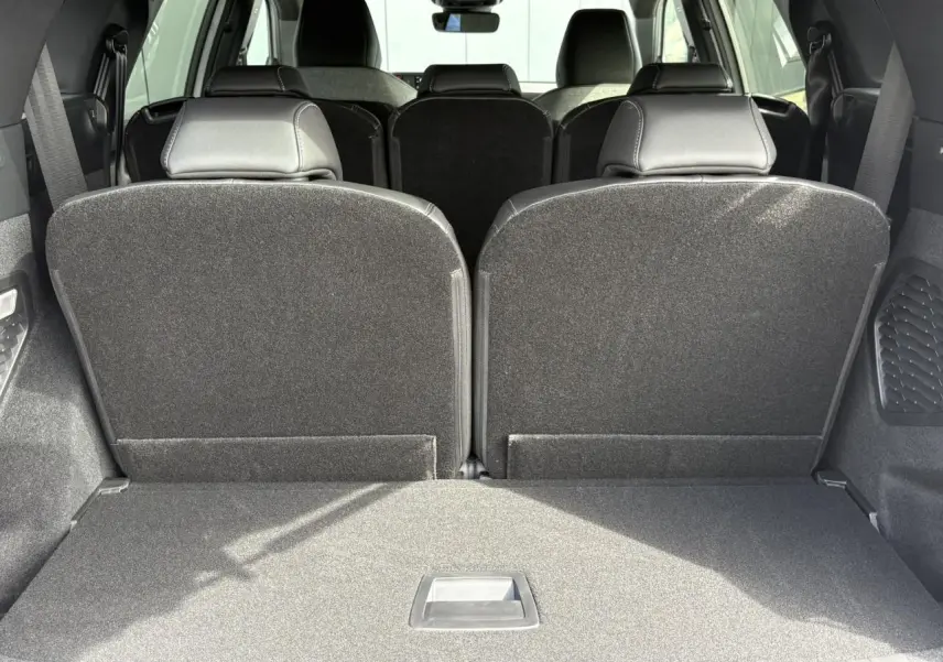 Coffre ouvert vu de l'arrière du Peugeot 5008 blanc Okénite avec banquette 3e rang rabattue.