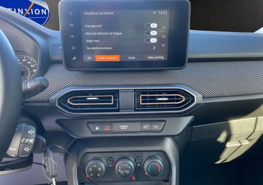 Vue rapprochée du tableau de bord noir de la Dacia Sandero Stepway 2025 avec écran tactile et commandes climatiques.