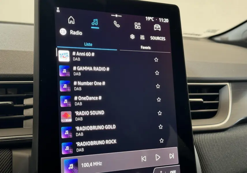 Écran tactile central du tableau de bord du Renault Captur blanc esprit Alpine E-Tech 2025 affichant les radios DAB.