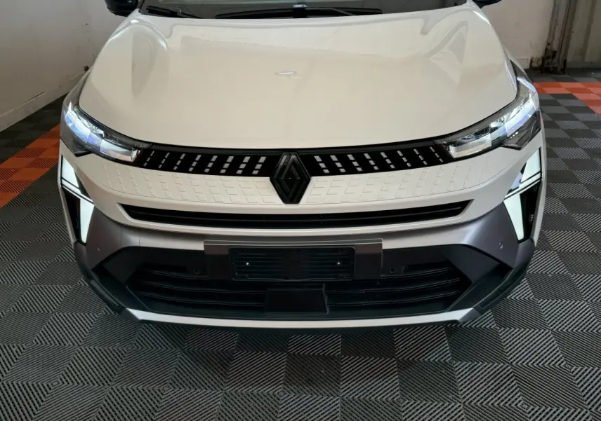 Vue frontale rapprochée du Renault Captur blanc esprit Alpine E-Tech 2025 avec calandre noire et feux LED distinctifs.