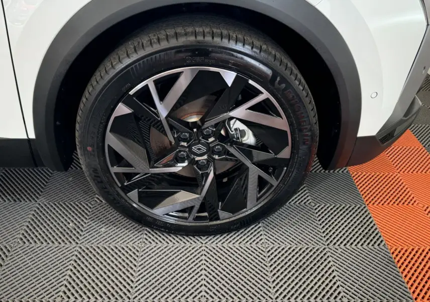 Gros plan sur la roue avant droite blanche du Renault Captur Esprit Alpine E-Tech avec jante noire et argentée au design géométrique.