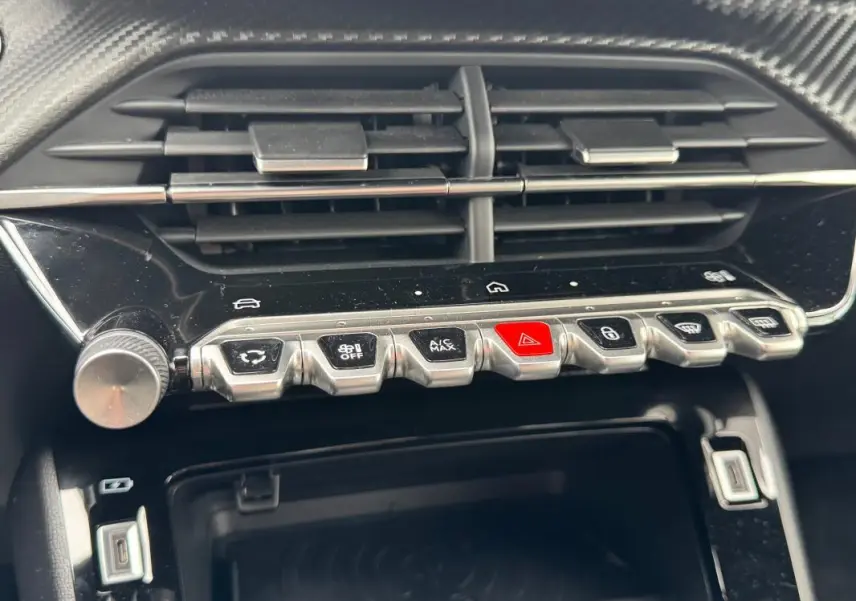 Gros plan sur la console centrale de la Peugeot 208 Hybrid 110 e-DCS6 GT 2025, montrant les boutons de commande et la prise USB.