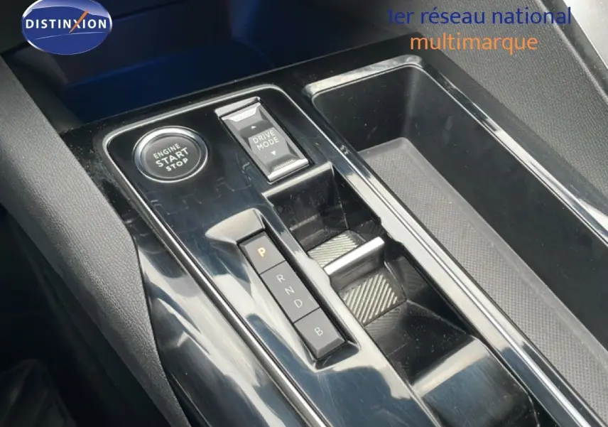 Vue rapprochée de la console centrale noire brillante du Peugeot 3008 1.6 Hybrid avec boutons start/stop et sélection de mode de conduite.
