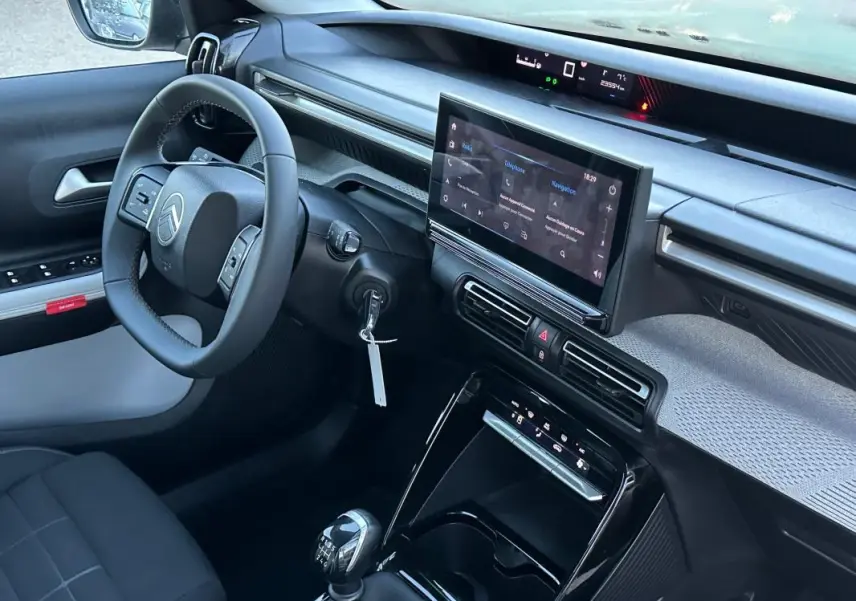 Vue intérieure côté conducteur de la Citroën C3 noire 2025, avec tableau de bord numérique et écran tactile central.