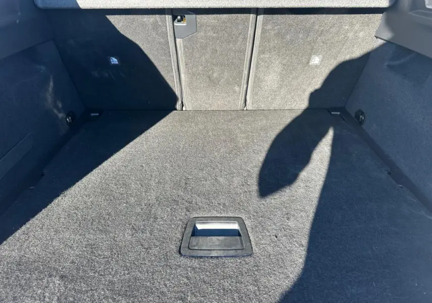 Vue intérieure du coffre spacieux et vide du Peugeot 3008 Hybrid 145 e-DCS6 Allure, revêtement en tissu gris.