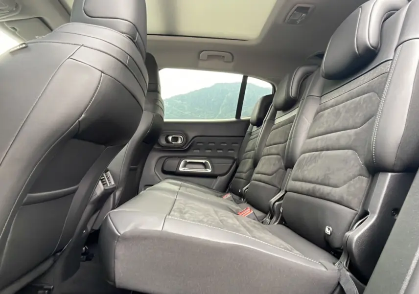 Vue latérale droite de l'intérieur arrière du Citroën C5 Aircross 2025, sièges en cuir noir avec surpiqûres apparentes.