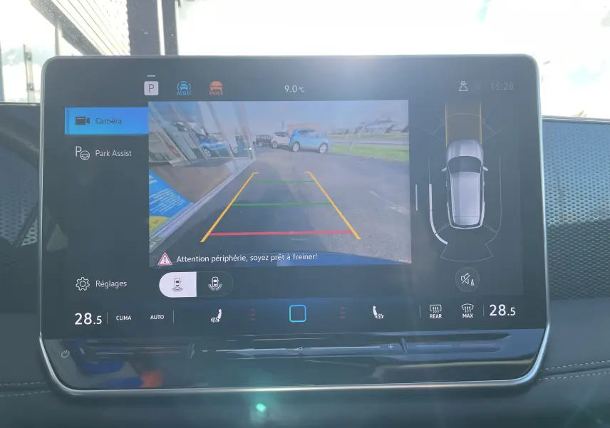 Écran tactile du Volkswagen Tiguan 2024 affichant la caméra de recul et l'assistance au stationnement, intérieur noir.