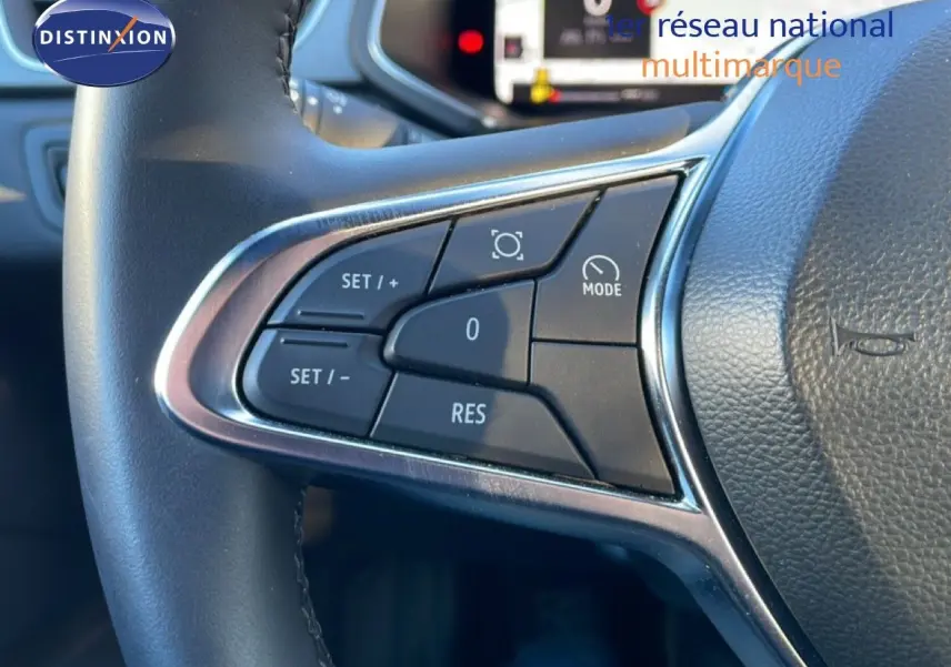 Gros plan sur les commandes au volant côté gauche du Renault Captur rouge désir métal avec toit noir, version 2025.