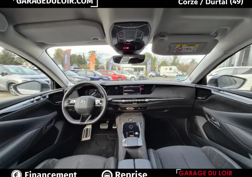 Vue intérieure avant du tableau de bord et volant cuir noir du DS4 beige avec écran tactile central et commandes modernes.