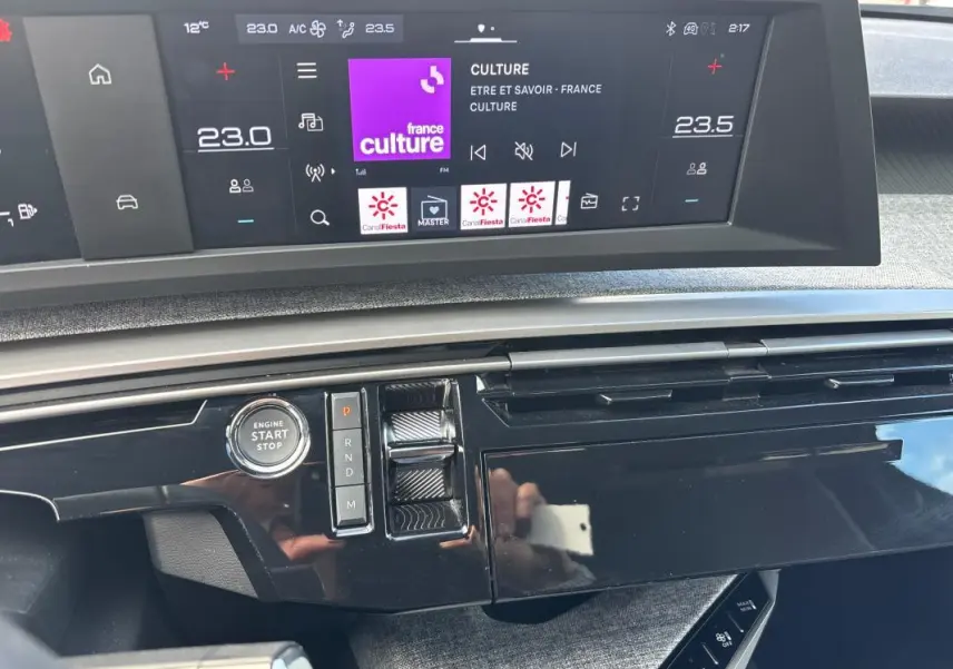 Vue rapprochée du tableau de bord du Peugeot 3008 Hybrid 145 e-DCS6 Allure gris, avec écran tactile et bouton start/stop.