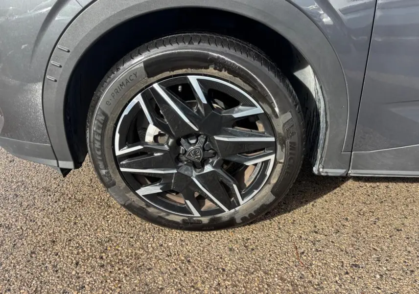 Gros plan sur la roue avant droite du Peugeot 3008 gris, jante alliage 19 pouces au design moderne.