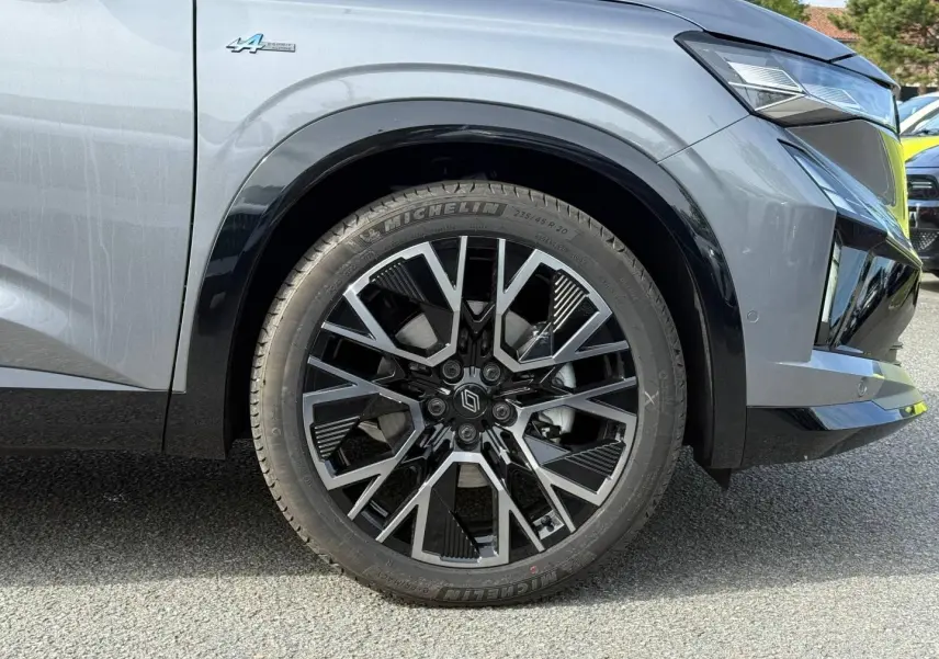 Gros plan sur la roue avant droite du Renault Austral gris Schiste satin avec jante alu noire et argentée et badge Alpine.
