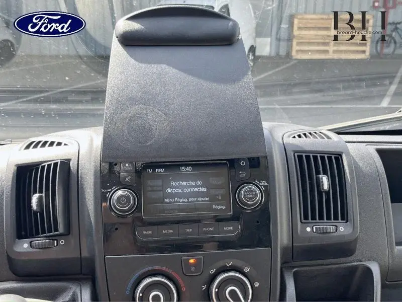 Vue intérieure du tableau de bord central du Citroën Jumper blanc, avec écran tactile et commandes climatisation visibles.