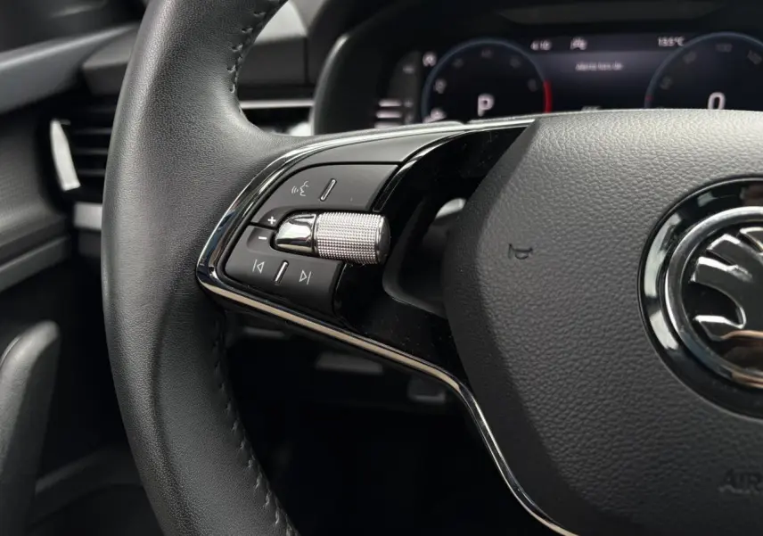 Gros plan sur le volant cuir multifonctions du Skoda Kamiq 2024, avec commandes audio et Digital Cockpit en arrière-plan.